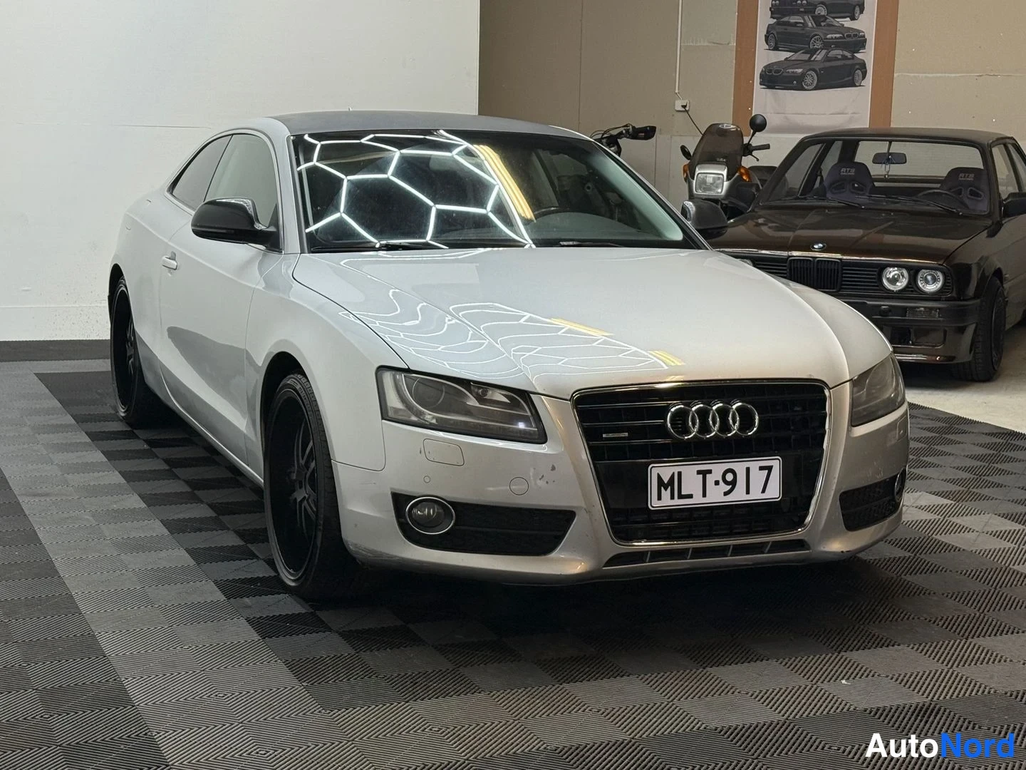 Etuviisto, nokka oikealle: Hopeanvärinen Audi A5 -coupe etuviistosta oikealta, mustat vanteet ja rekisterikilpi.