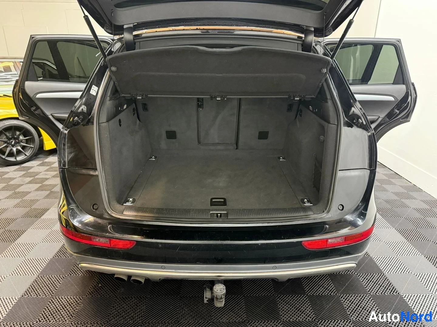 Takaa: Audi Q5:n tavaratila suoraan takaa, tavaratilan luukku ja takaovet auki, vetokoukku puskurin alla.
