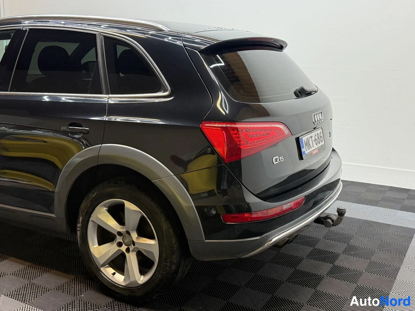 Takaviisto: Mustan Audi Q5:n takaviisto: rekisterikilpi, Q5-merkintä ja perävaunukoukun palloupäät näkyvät.