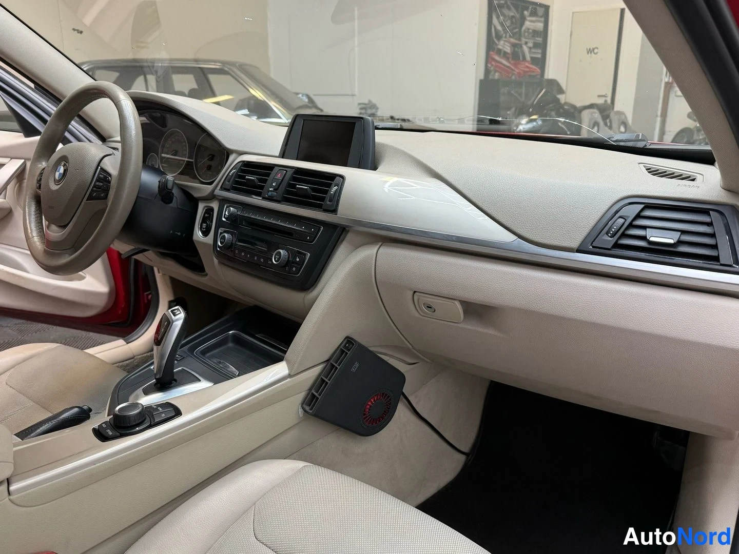Muu: Auton sisätilat: BMW-ohjauspyörä, vaalea kojelauta, keskikonsolissa automaattivaihteen valitsin, infotainment-näyttö ja kiinteä ventilaattori.
