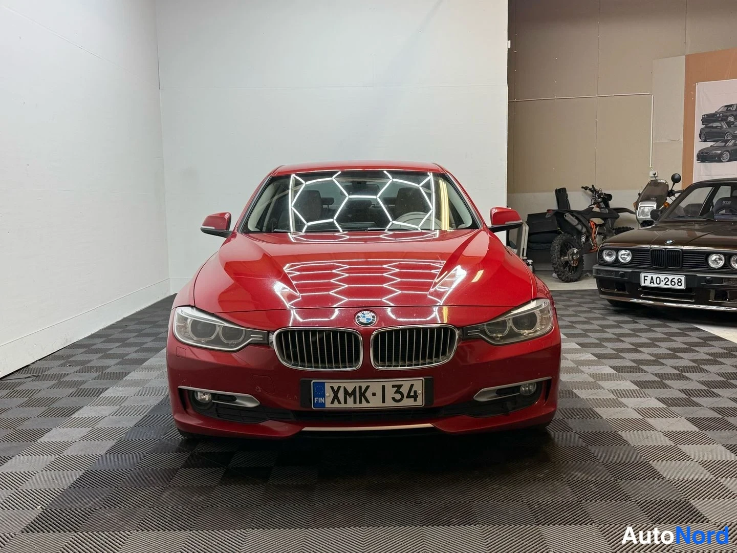 Edestä: Punainen BMW 3-sarjan sedan suoraan edestäpäin kuvattuna, rekisteritunnus.