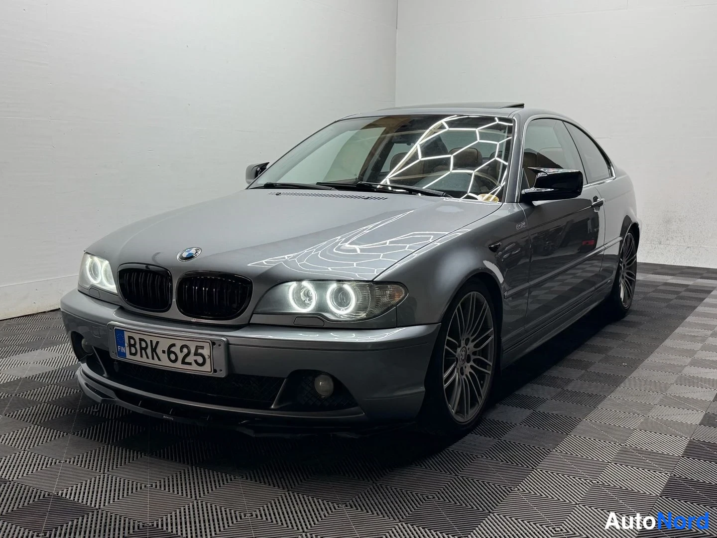 Etuviisto, nokka vasemmalle: Hopeanharmaa BMW Coupé kuvattu kulmasta edestä vasemmalla, rekisterikilpi, musta kiiltävä etusäleikkö, LED-ovalaudat ajovaloissa, sade ja monipaikkaise