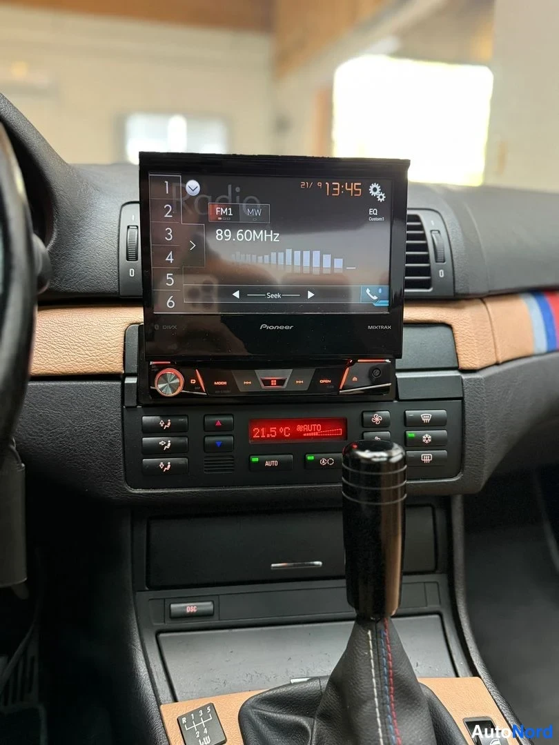 Yksityiskohta: Pioneer-näyttöradio näyttää FM1 89.60MHz radiota, kellonaika 13:45, ja ilmastointi näyttää 21.5°C AUTO