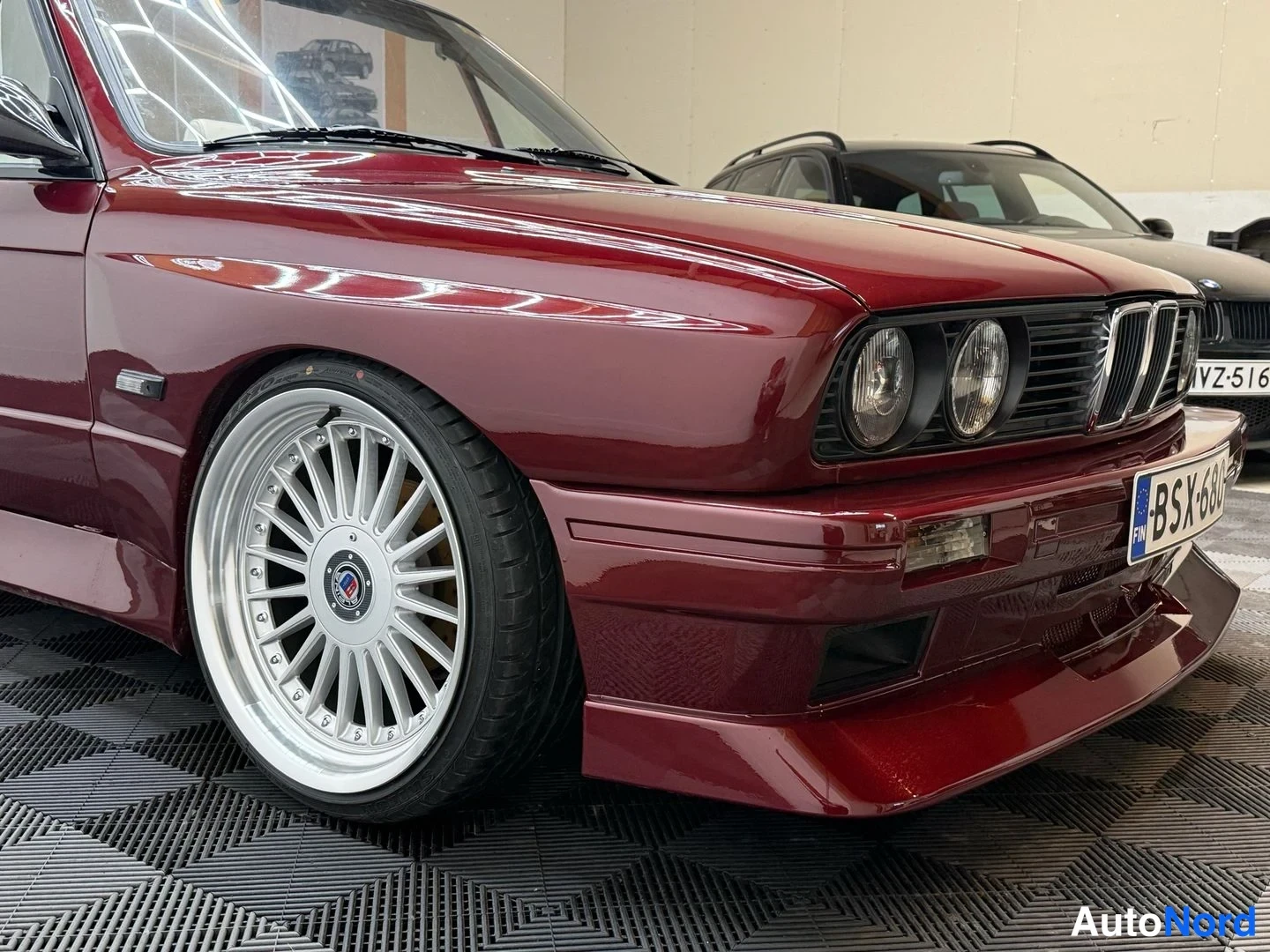 Etuviisto, nokka oikealle: Punaisen BMW:n etukolmivariantti: maski ja pyöreät ajovalot, Alpina-vanne, rekisteritunnus.