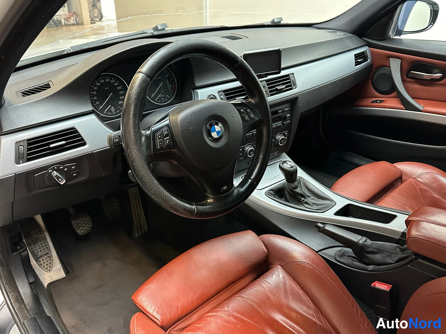Muu: BMW:n ohjaamo: punaruskeat nahkaistuimet, M-merkkinen ohjauspyörä ja käsivaihteisto.