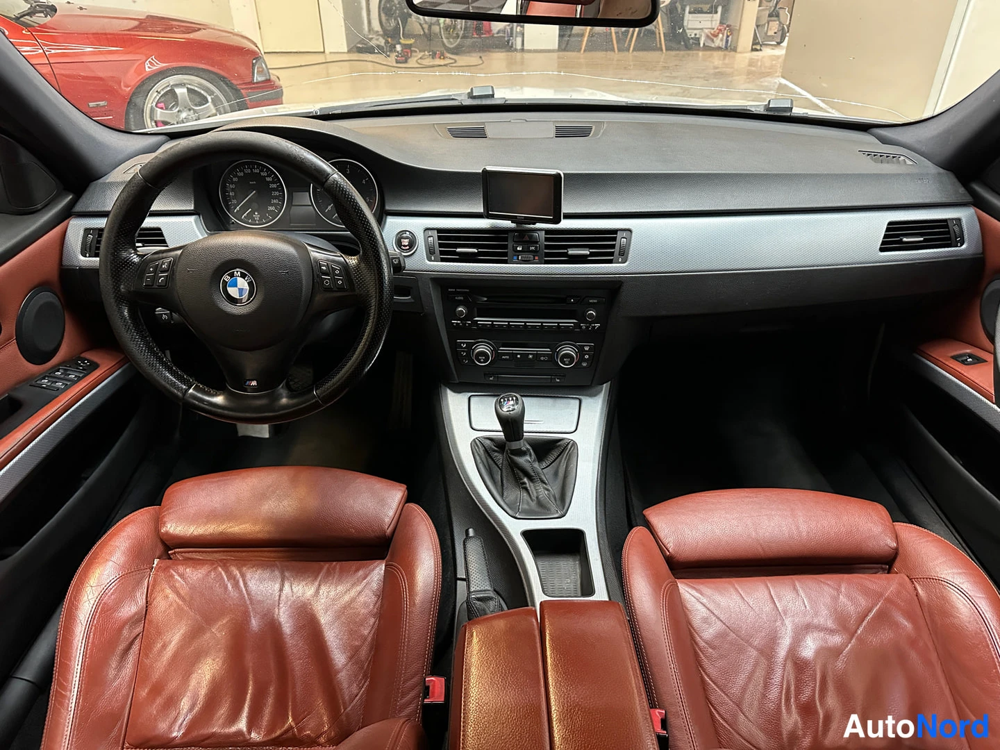 Muu: Auton sisätilat: BMW-ohjauspyörä, analoogiset mittarit, musta kojelauta, kätevaihto ja punaruskeat nahkaistuimet. Kojelaudan päällä kiinnitetty pieni näyttö.
