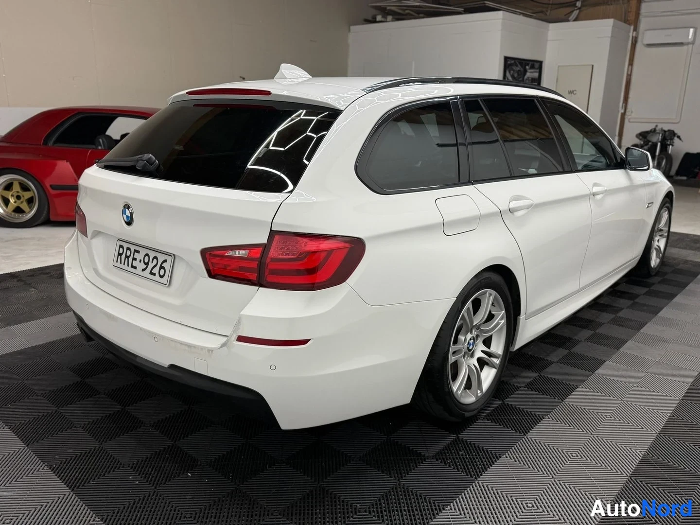 Takaviisto: BMW 5 Touring -Auton takakolmeneljänneskuva; rekisteritunnus, valkoinen koriväri ja hopeavanteet