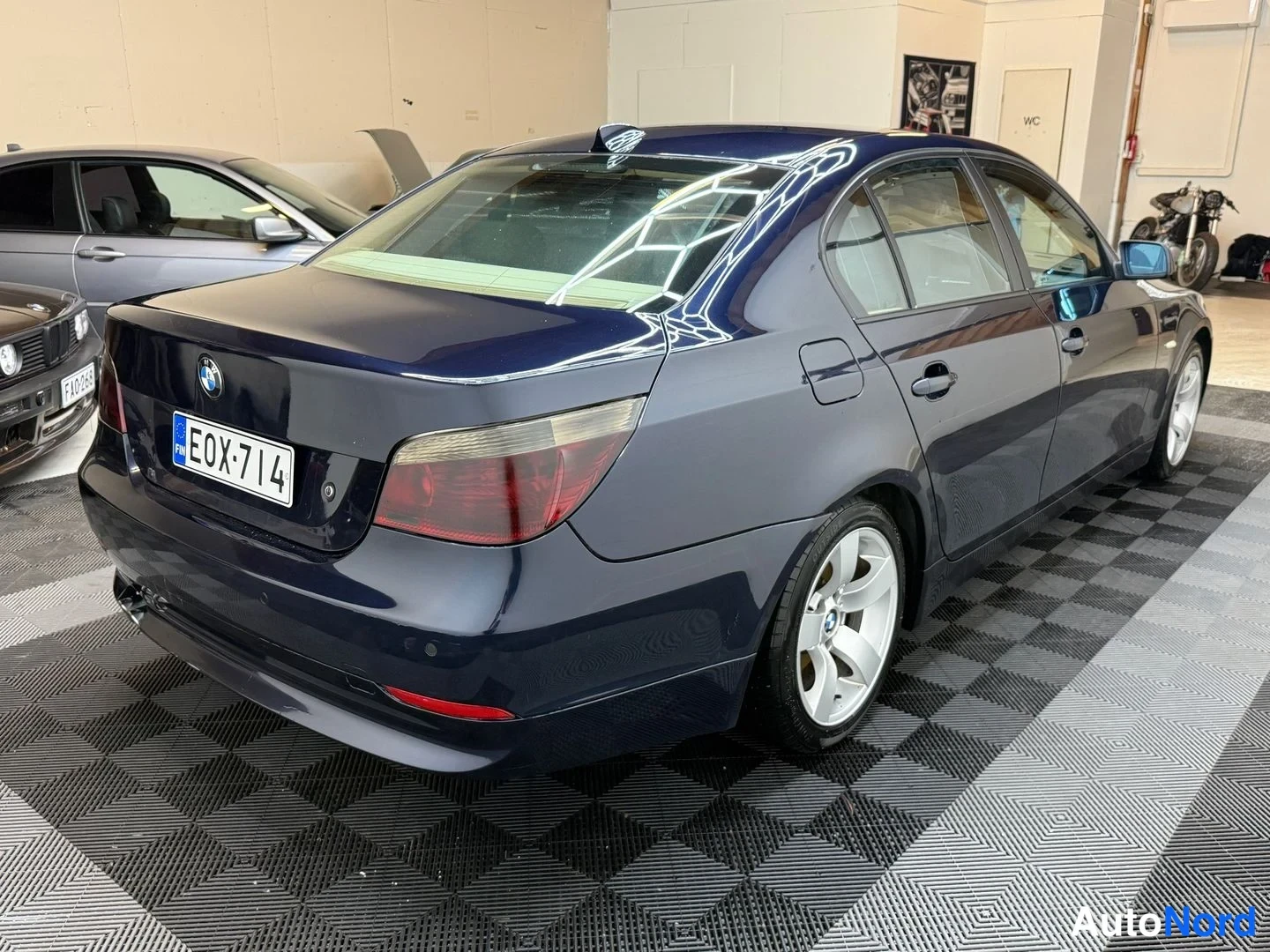 Takaviisto: Takaosakulmanäkymä tummansinisestä BMW-sedanista, rekisterikilpi näkyvissä.