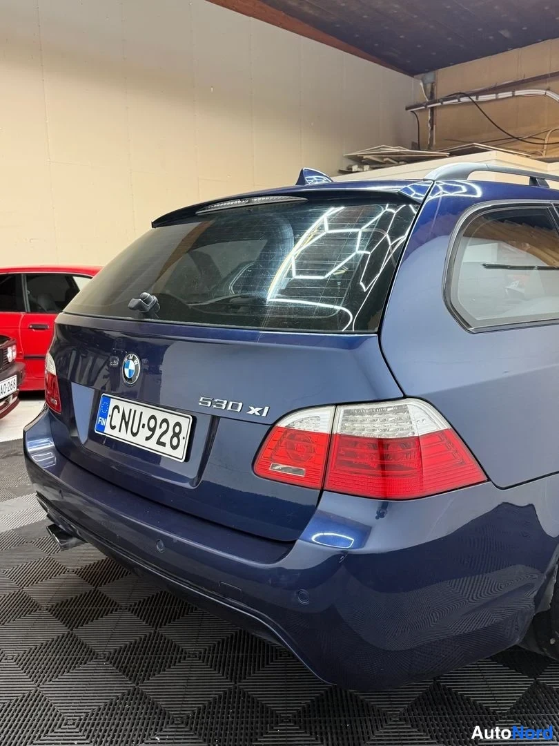 Takaa: Takanurkkaus sinisestä farmariautosta läheltä kuvattuna, rekisteritunnus, kannessa 530 xi -teksti ja BMW-merkki.