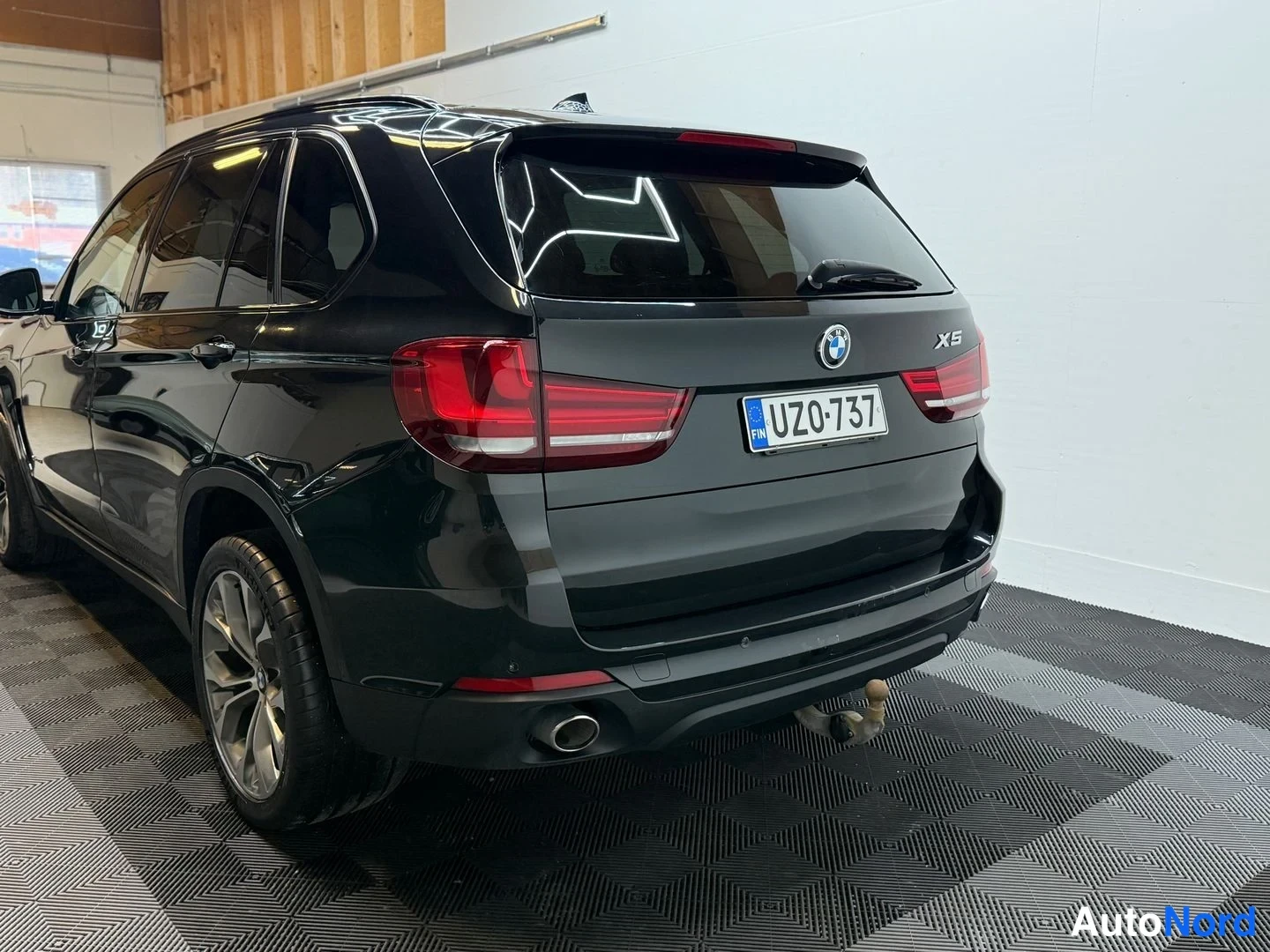 Takaviisto: BMW X5:n takaosa ja vasen kylki, rekisterikilpi, vetokoulu ja pakoputki näkyvissä.