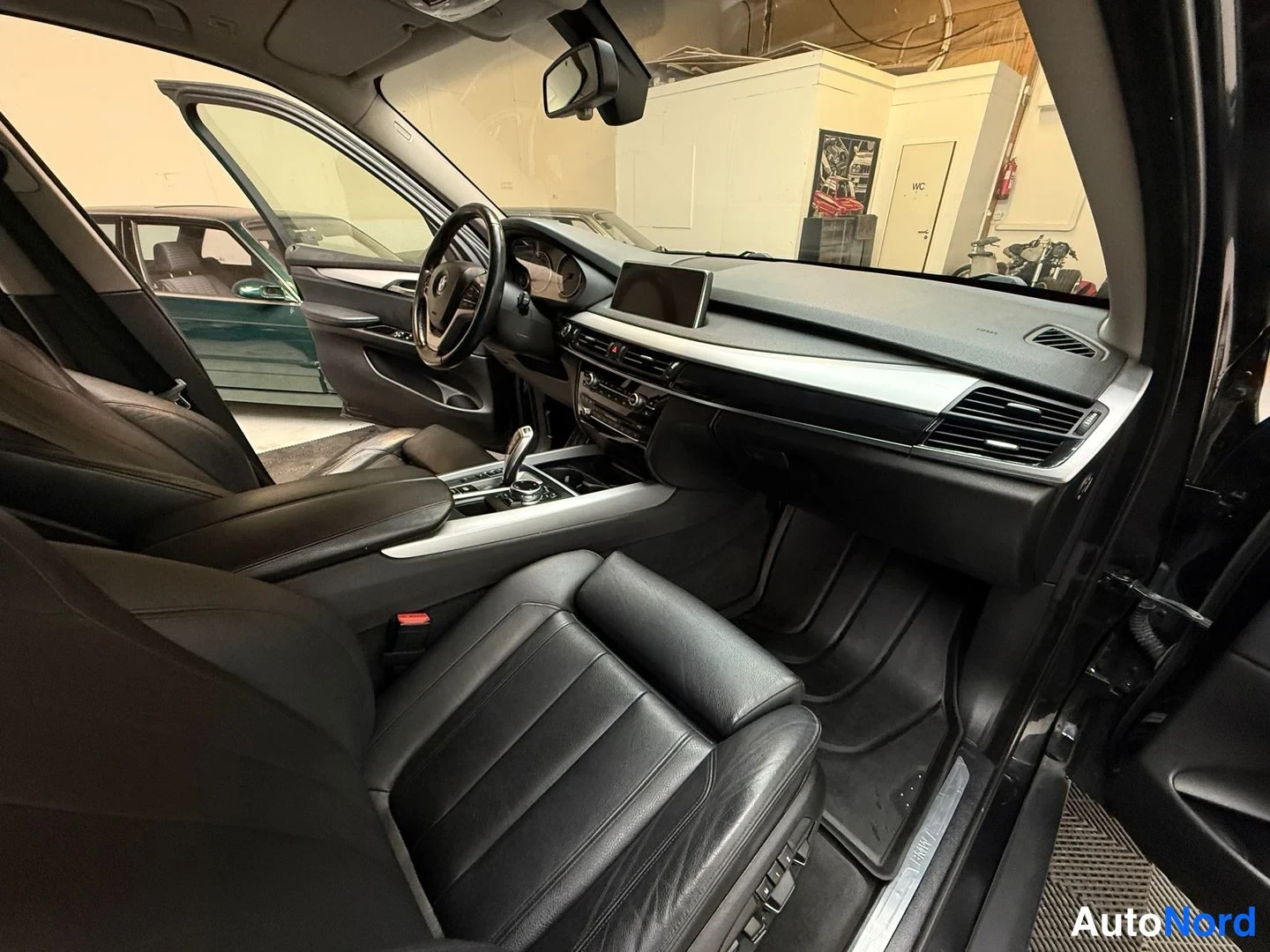 Muu: Ajonäytön kulma ajokkin paikalta: BMW X5 (F15) kkoista mustia, nahat istuimet ja keskitunnin koko näkyviin.