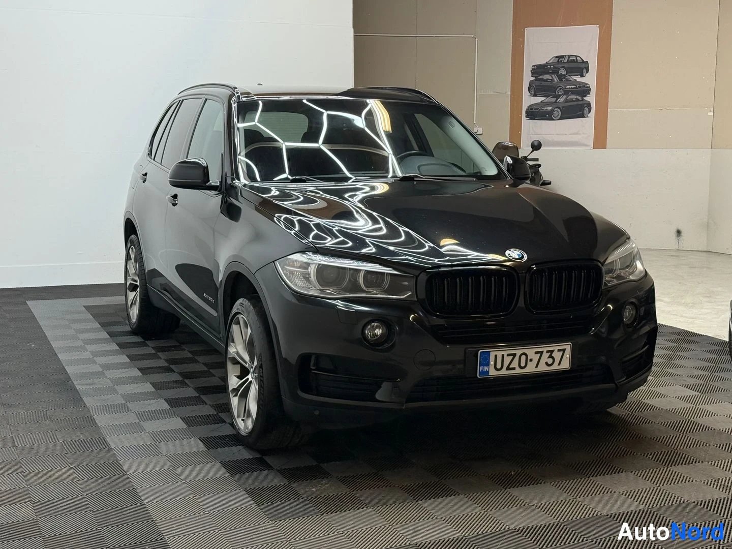 Etuviisto, nokka oikealle: Musta BMW X5 farmari kulmassa edessä oikealta, rekisteritunnus.