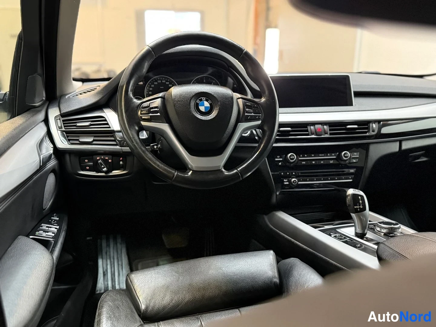 Muu: BMW X5:n ohjaamo mustilla nahkaistuimista, ohjauspyörässä BMW-logo ja keskitunnin suuri näyttö.