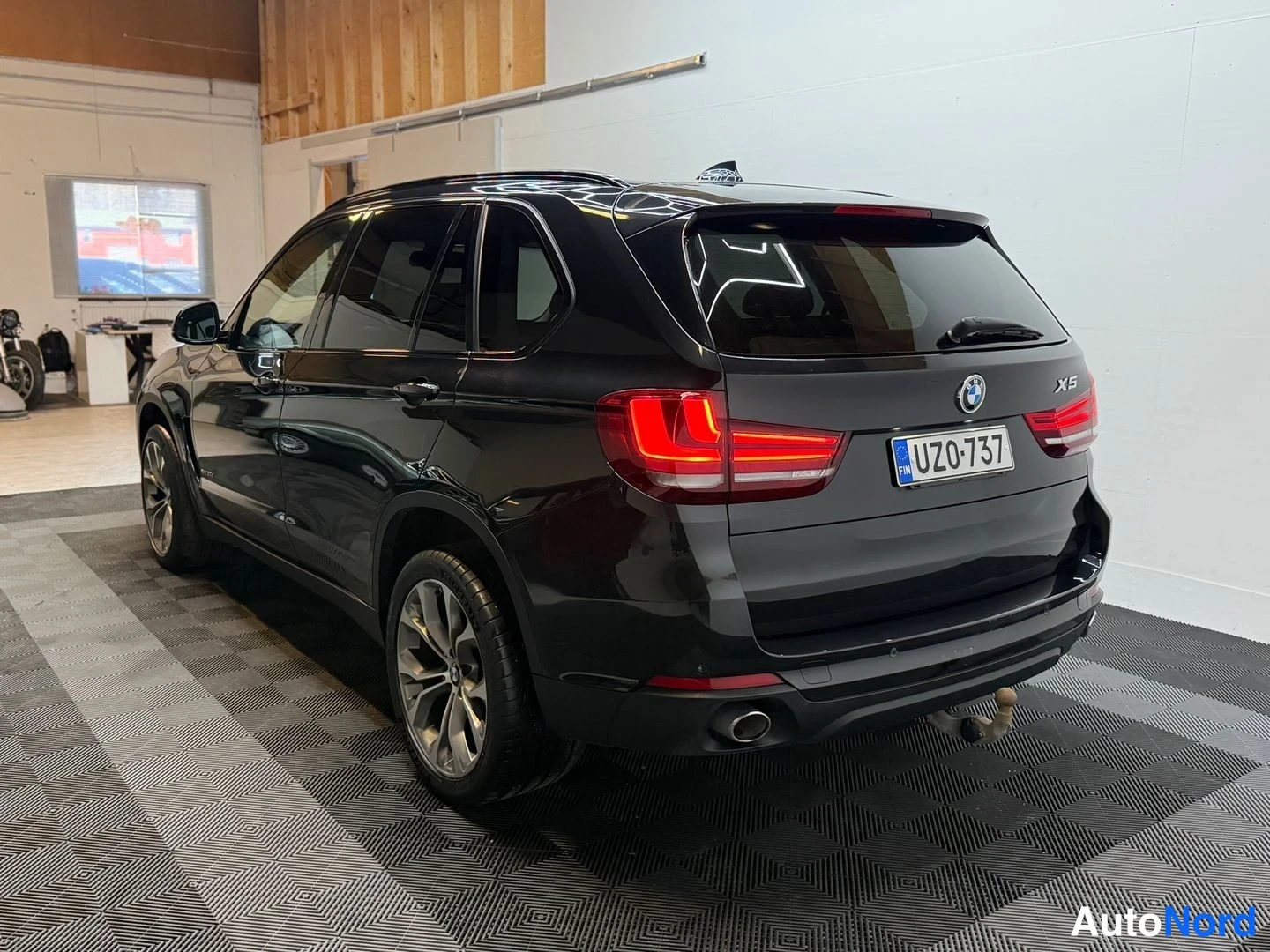 Takaviisto: BMW X5:n takaosa ja vasen kylki kolmivartalokulmassa, rekisterikilpi.