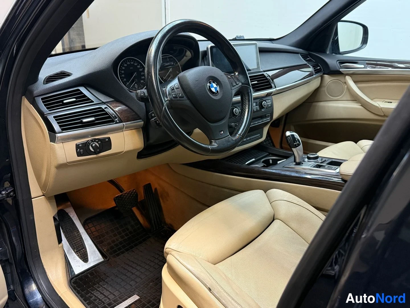 Muu: Auton sisätilat: BMW-ohjauspyörä, kojelaudan mittaristo, keskikonsolin näyttö ja vaihtaja sekä beige nahkainen etuistuin.