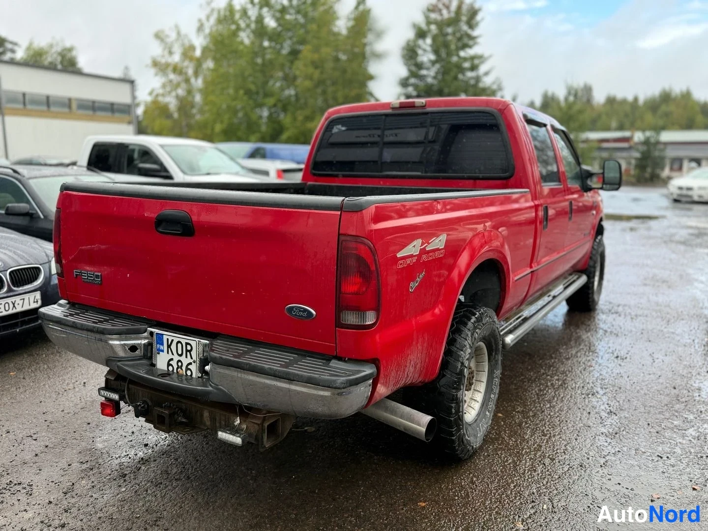Takaviisto: Punaisen Ford F-350:n takakulma oikealta, takapuskissa rekisterikilpi ja tunnelma. Korissa F350- ja 44 Off Road -merkinnät.