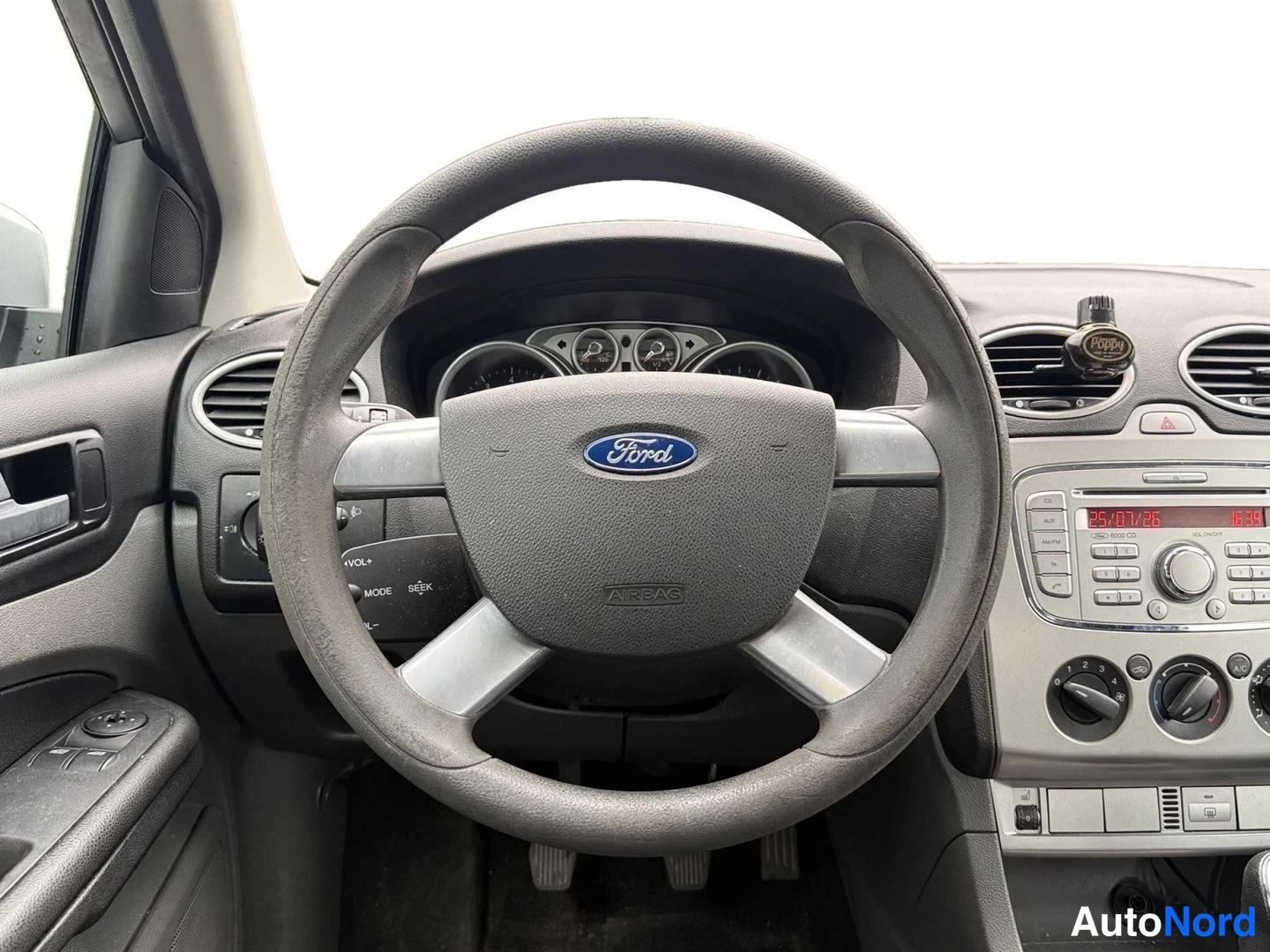 Edestä: Ohjauspyörä ja kojelauta: Ford-merkkinen ohjauspyörä, mittaristo ja keskikäytävän radio- ja ilmastointilaitteet.