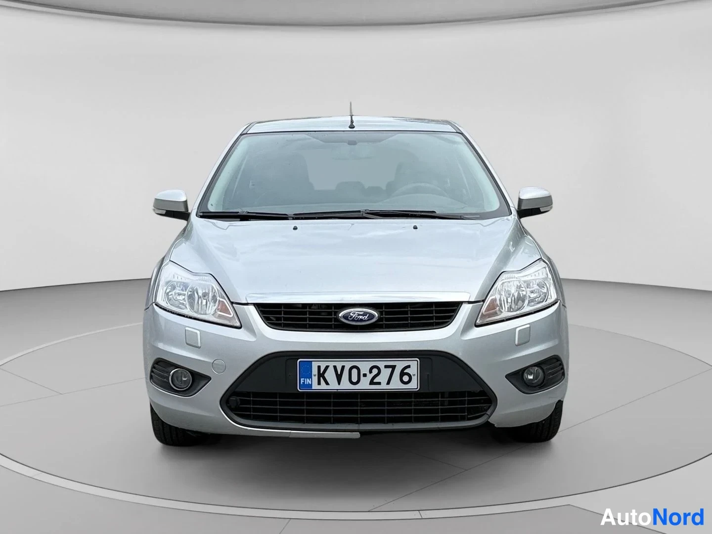 Edestä: Hopeanvärinen Ford Focus edestäpäin; grilli, ajovalot ja suomalainen rekisterikilpi KV0-276 näkyvät selkeästi.