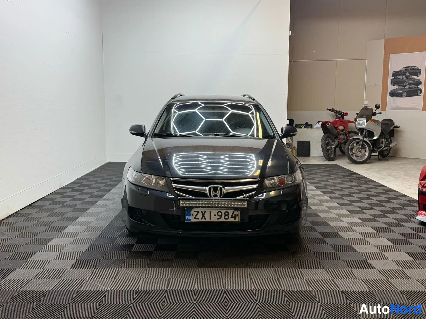 Edestä: Honda Accord -farmarin suora etukuva: musta koriväri, Honda-merkki säleikössä, LED-pituusvalo ja kilpi FIN