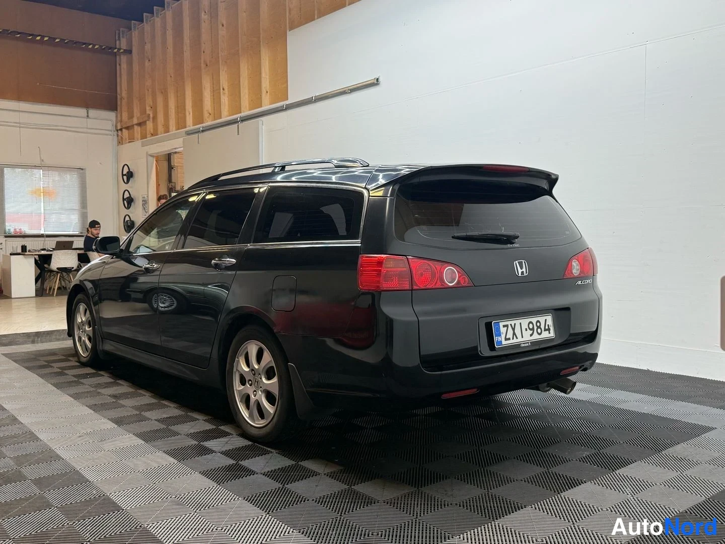Takaviisto: Musta Honda Accord Tourer -farmari kuvattu kolmeneljännesnäkymässä takaosasta oikealta näkyen; takavalojen punaiset osat, H-merkki ja rekisterikilpi näkyvät.