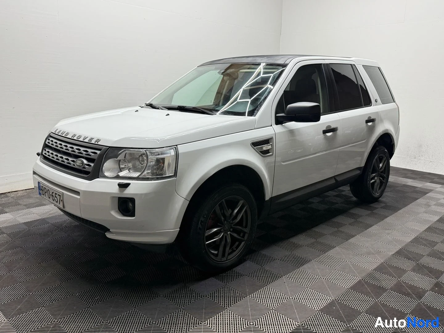 Etuviisto, nokka vasemmalle: Land Rover Freelander 2 etukulmasta, nokka vasemmalla, valkoinen