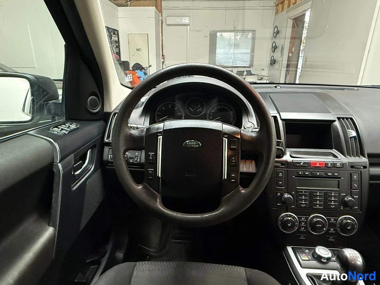 Muu: Ohjauspyörö ja mittaristo lähikuvassa, Land Rover -logo ohjauspyörässä.