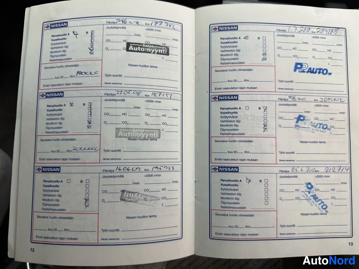 Muu: Avattu Nissanin huoltokirja, sivut 12–13, huoltomerkintöjä mm. Salon Automyynti- ja P-Auto-leimoilla.