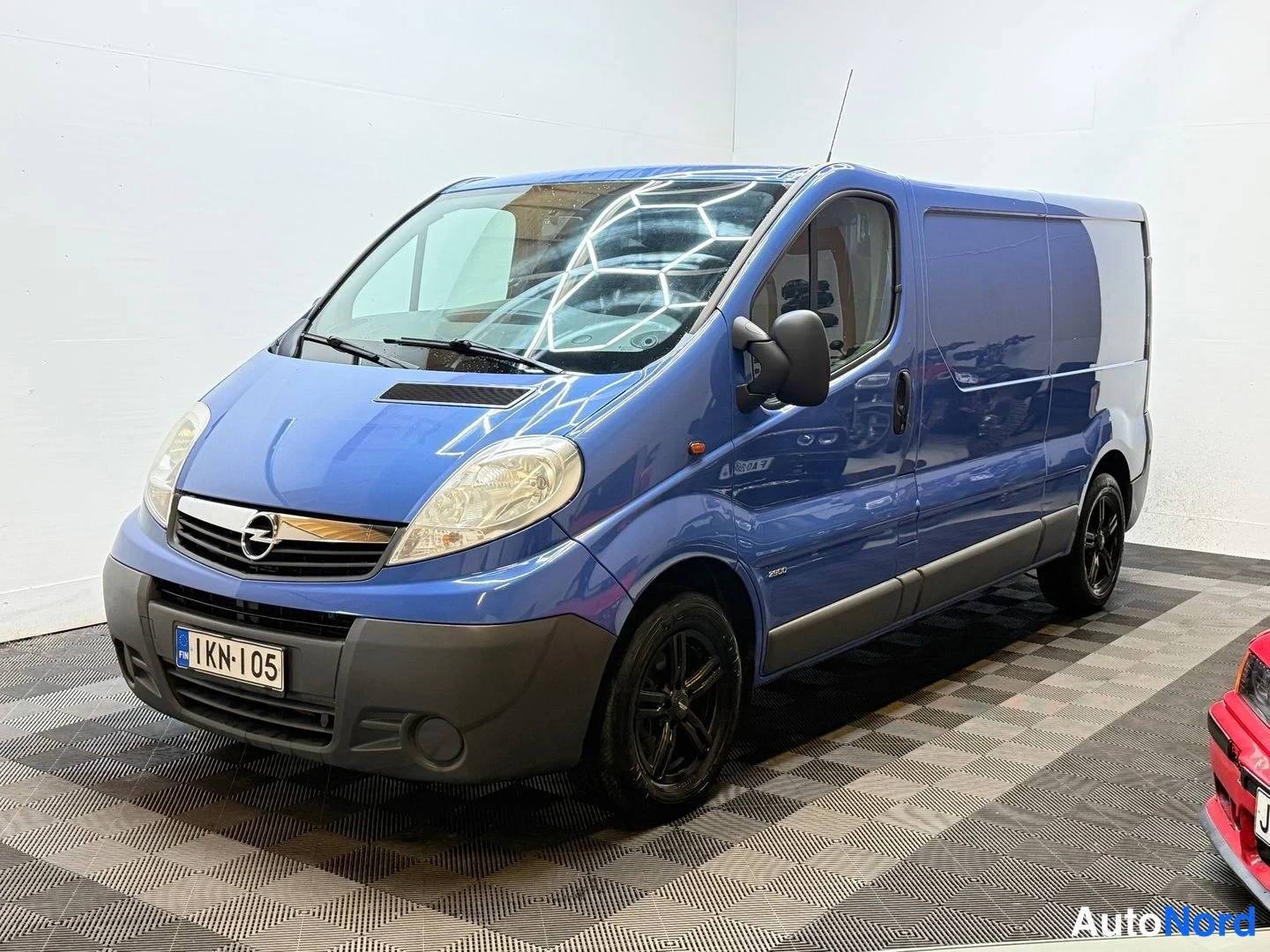Etuviisto, nokka vasemmalle: Opel Vivaro -pakettiauto etviistosta vasemmalle, sininen koripaneelit, rekisteri