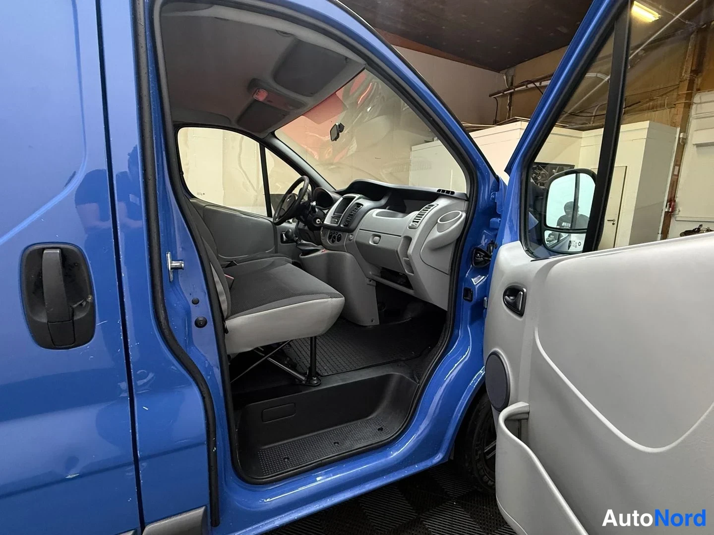 Muu: Sininen pakettiauto avoimilla ovilla, sisätilat näkyvät: ohjauspyörä, kojelauta ja istuimet, korin maali on sininen.