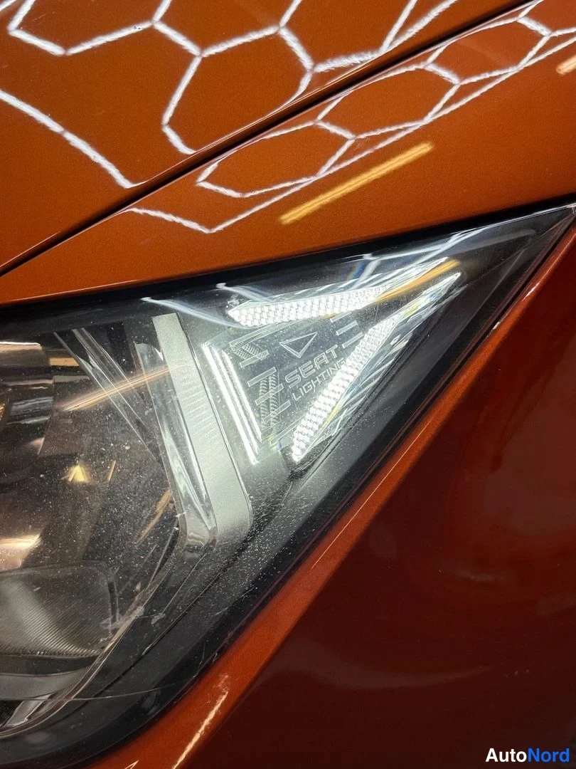 Edestä: Lähikuva Seat Ibiza- auton etuvalaisimesta, valaisimessa Seat- logo.