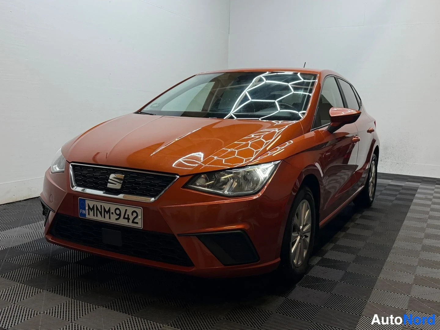 Etuviisto, nokka vasemmalle: Seat Ibiza edessä vasemmalta kuvattuna, koko auto näkyy valkoisella taustalla mustalla lattialla.