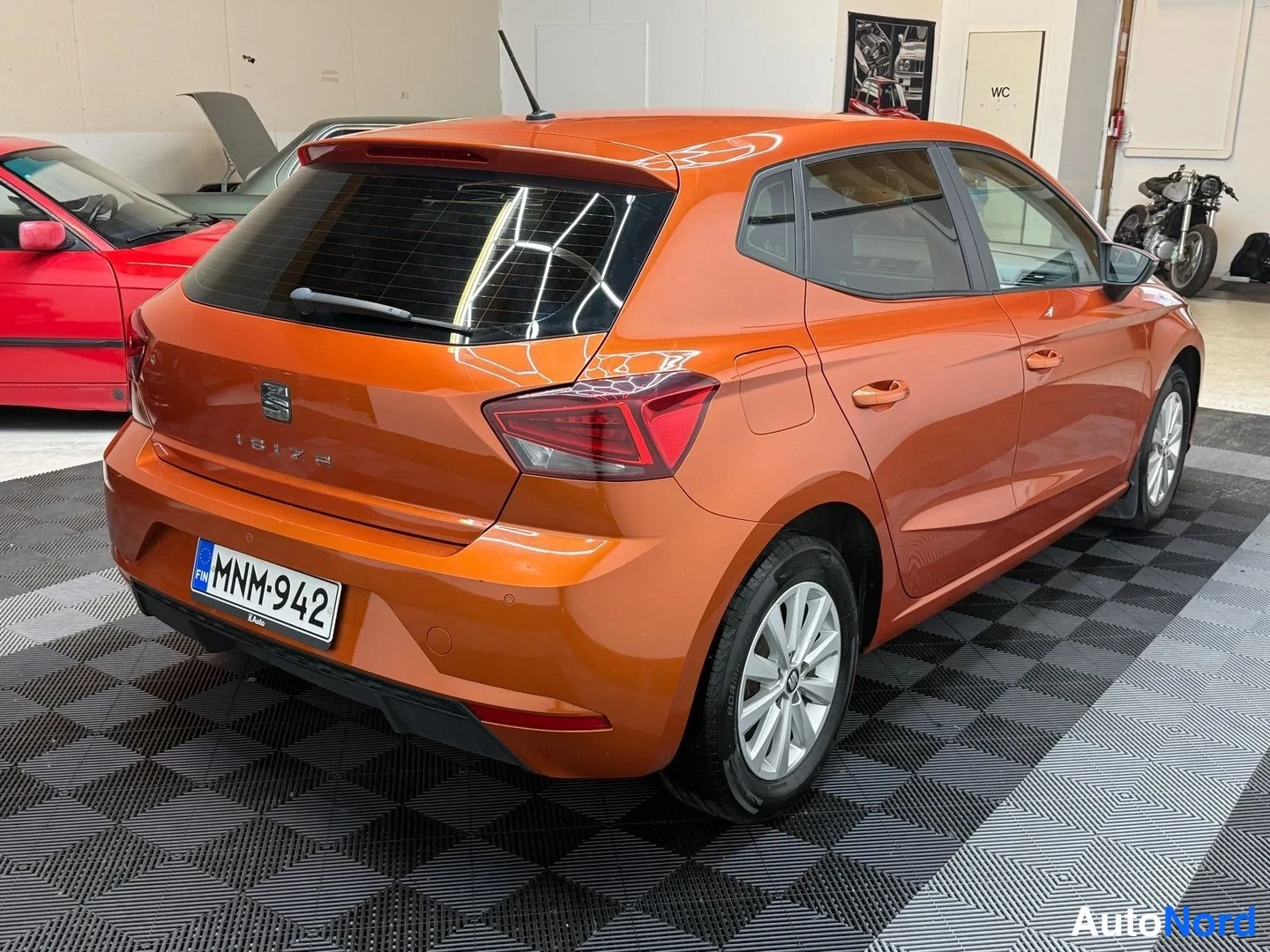Takaviisto: Oranssi Seat Ibiza takaviistosta vasemmalta, takavalo ja rekisterikilpi näkyvissä.