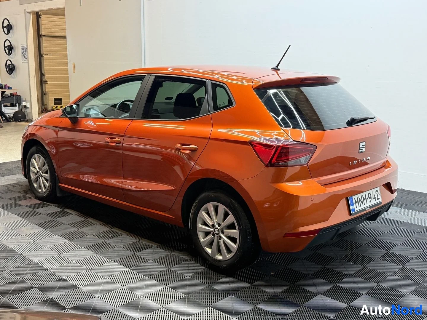 Takaviisto: Oranssi Seat Ibiza -viistoperä takaa sivulta, rekisteritunnus.