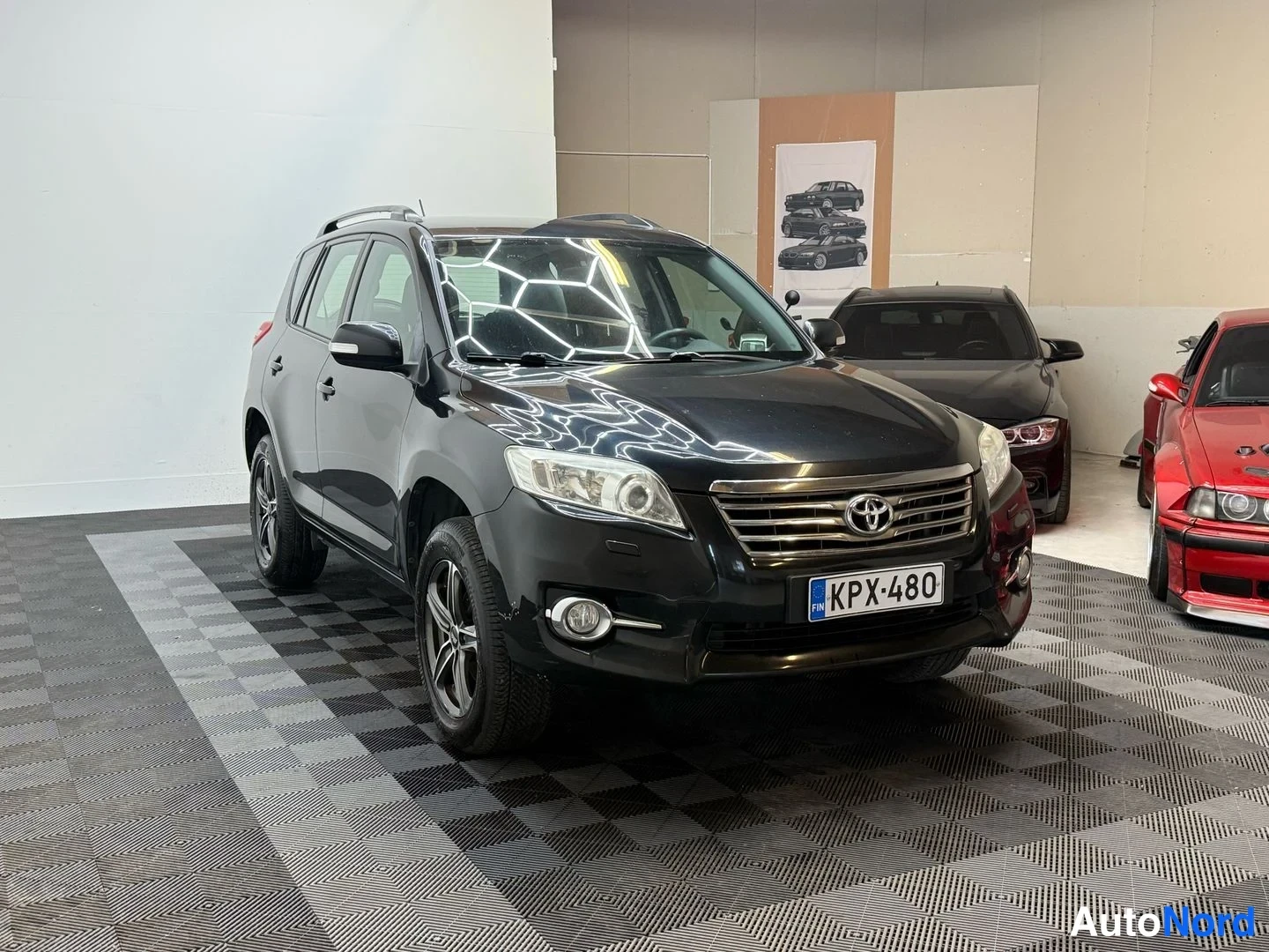 Etuviisto, nokka oikealle: Toyota RAV4 musta, etukulma oikealta, rekisterikilpi, kaiteet katolla.
