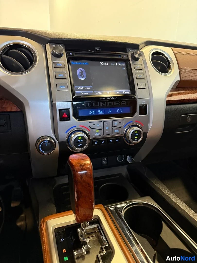 Muu: Toyota Tundran keskikonsoli: JBL-näyttö, Bluetooth-valikko (22:41), automatiikan nappiryhmä (AUTO, OFF, A/C, R/N/D/P) ja puokoristeinen vaihtajan nuppi.