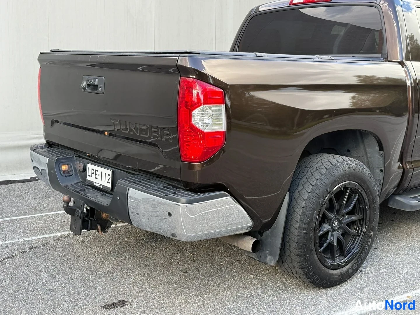Takaviisto: Toyota Tundra -farmarityyppisen lavallisen autun takakulma. Rekisterikilpi. Takapuskuli on kromainen, lavan sivussa on Tundra-teksti.