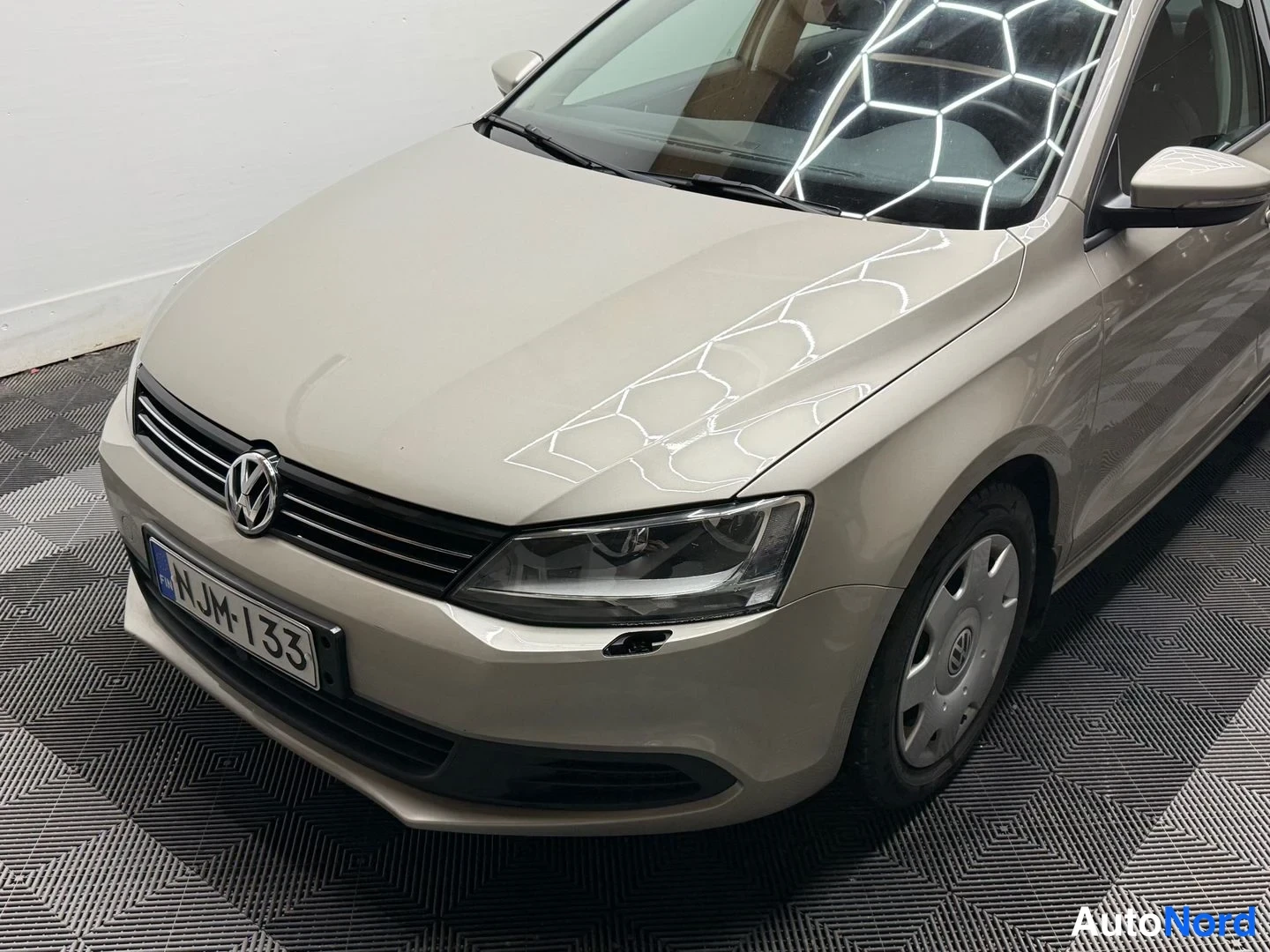 Etuviisto, nokka vasemmalle: Volkswagen Jettan etukulma ylhäältä vasemmalta, etusäleikkö ja kylki näkyvissä.