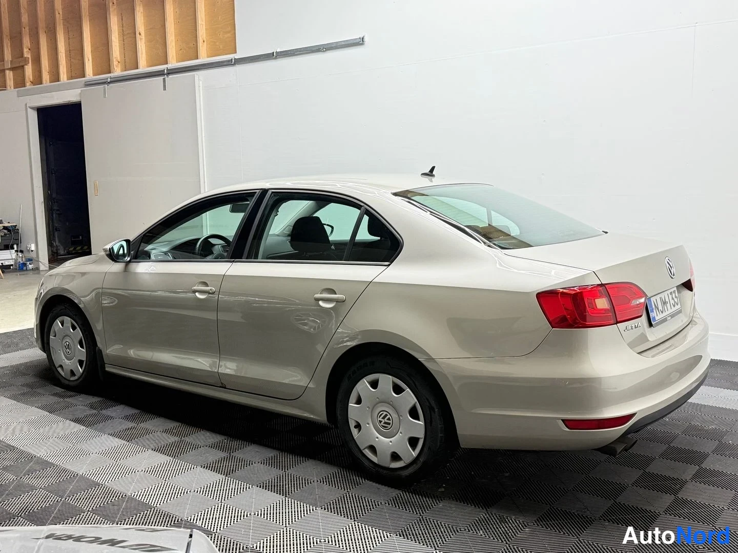 Takaviisto: Volkswagen Jetta -sedanin takakulma sisätiloissa, vaaleanbeige kori ja vasen sivu näkyvissä.