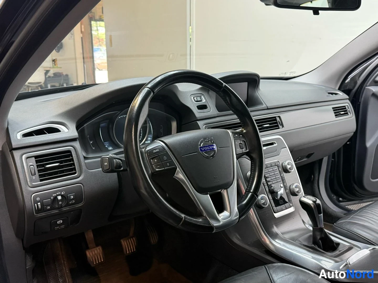 Muu: Ohjaamo; Volvo-ohjauspyörä, kojelauta, vaihteenvalitsin ja keskikonsolin säätimet näkyvät.
