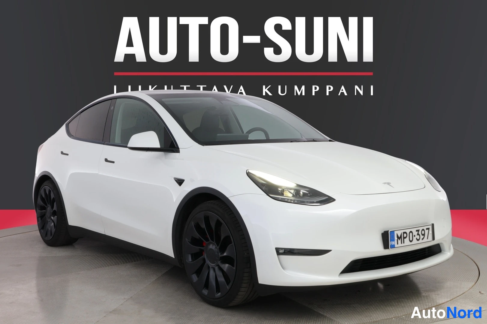 Etuviisto, nokka oikealle: Valkoinen Tesla Model Y etu-kulmanäkymässä, rekisteritunnus MP0-397, tummat vanteet.