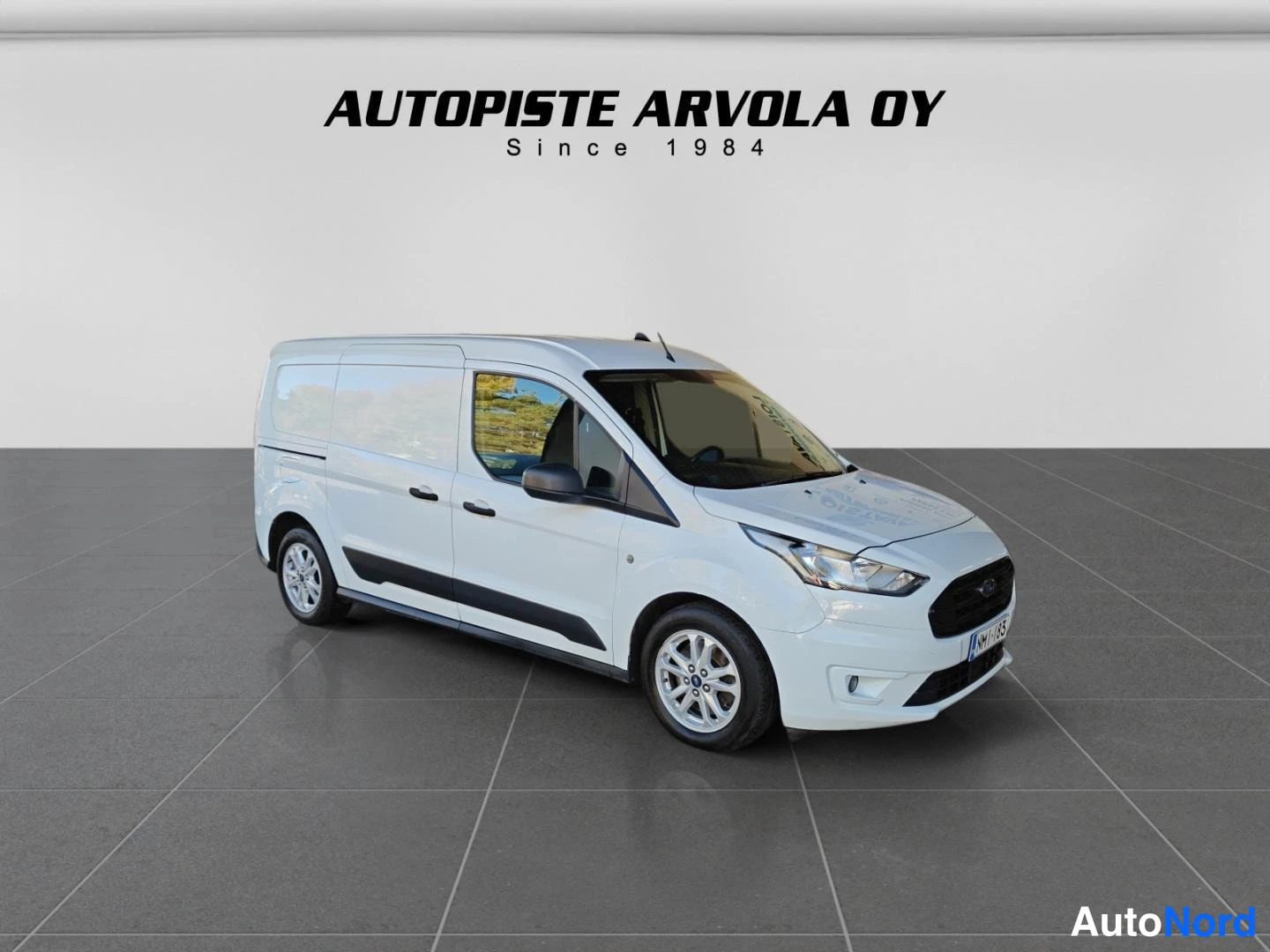 Etuviisto, nokka oikealle: Valkoiset Ford Transit Connect -pakettiauto kulmassa edestä oikealta näkyvä etupuoli ja oikea kylki, valoisa studiotaustainen kuva.
