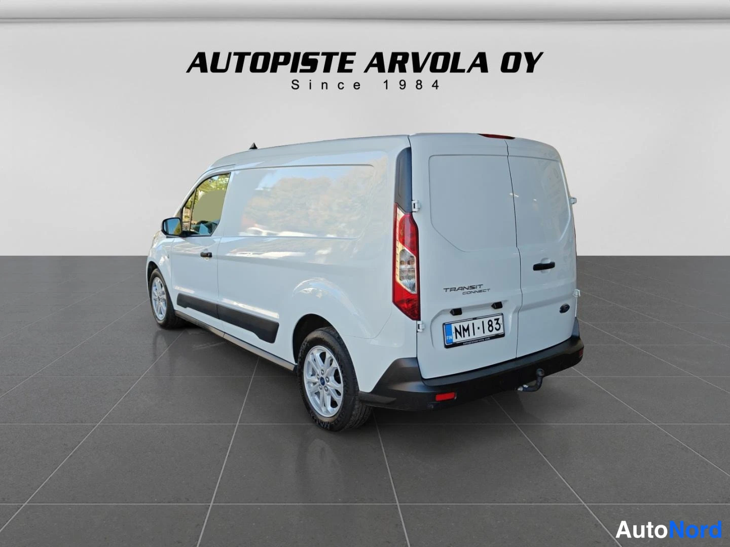 Takaviisto: Ford Transit Connect -pakettiauton takakulma: valkoinen koripanelointi, yhden takavanteen näkyvä osa ja rekisterikilpi.