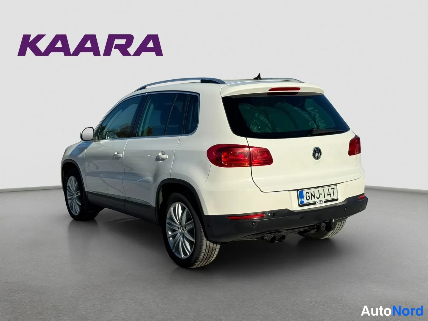 Takaviisto: Auton takakulmatakaa valkoinen hatchback, rekisteritunnus, kattokaaret ja takavalot näkyvissä.