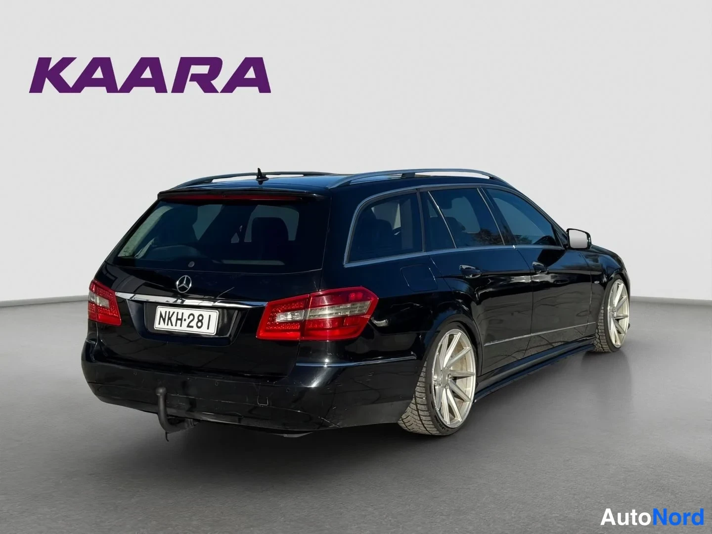 Takaviisto: Musta Mercedes-Benz farmarin takaviisto, punaiset takavalot, rekisterikilpi, vetokoukku ja hopeat vanteet.