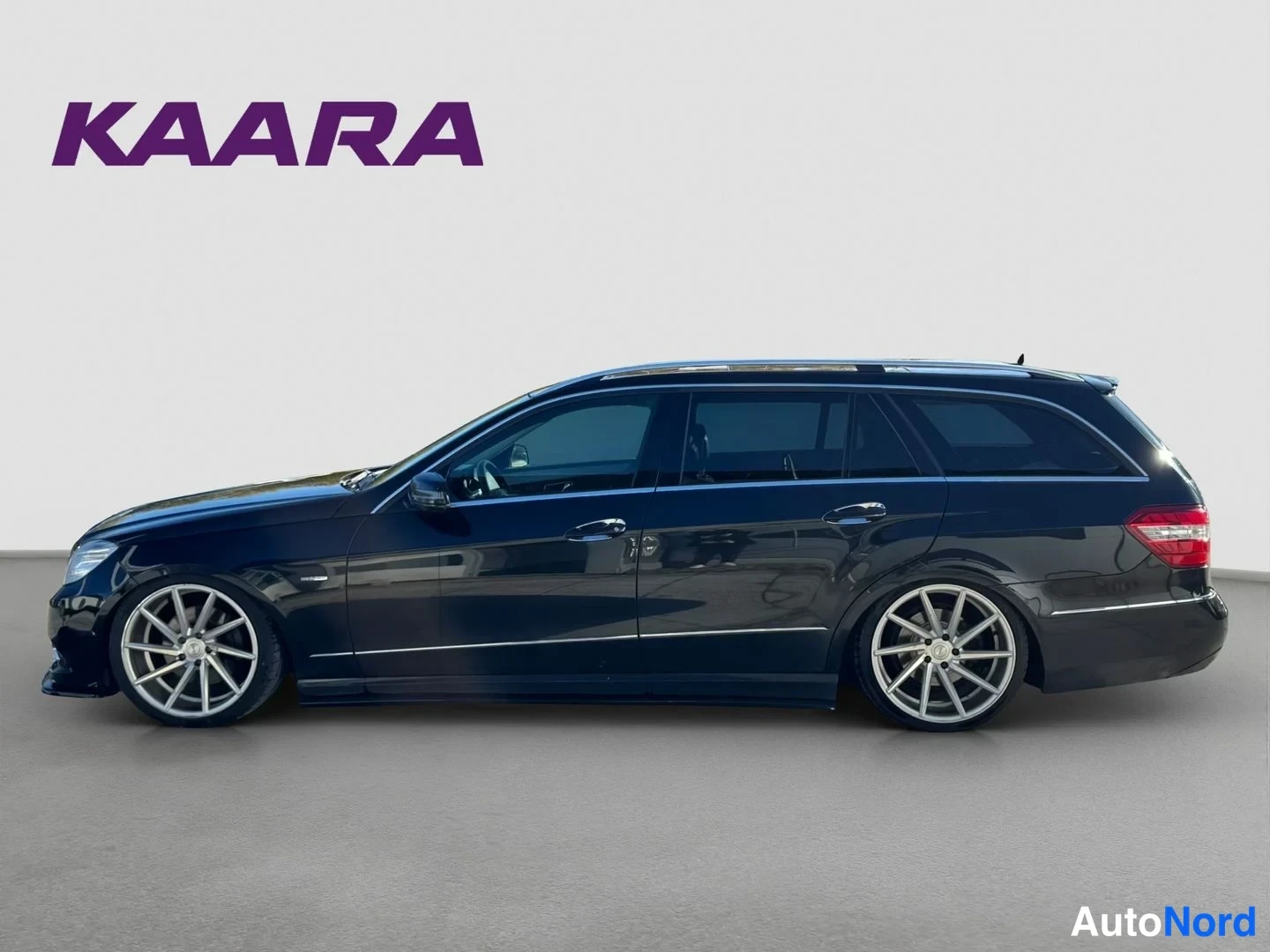 Takaviisto: Mustan Mercedes-Benz farmariauto sivuprofiili valkoista taustaa vasten
