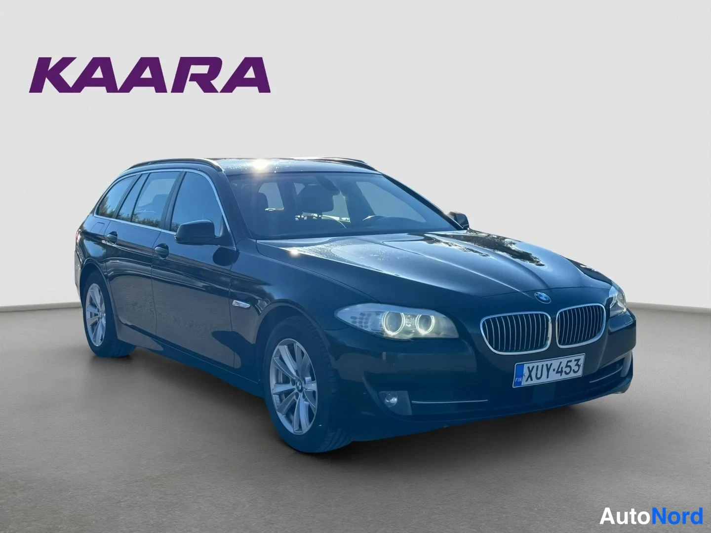 Etuviisto, nokka oikealle: Mustan BMW 520 Touring -farmarin etukulma vasemmalta, rekisteritunnus