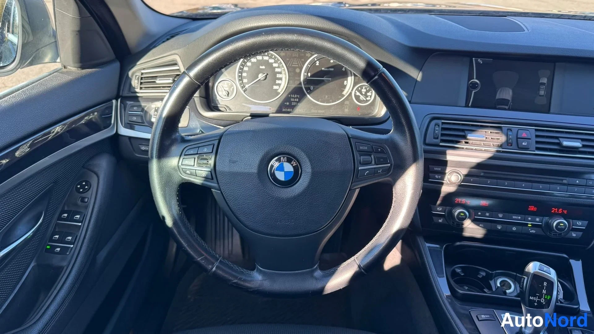 Muu: Kuljettajan näkökulma BMW:n ohjaamoon: mittaristo nopeus- ja kierrosmittareilla, monitoimiohjauspyörä ja keskikonsoli näytöllä.