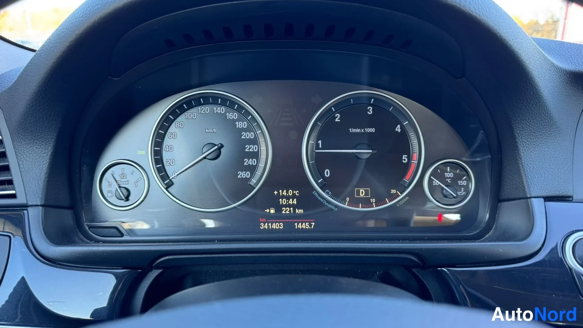 Muu: Lähikuva BMW:n mittaristosta: nopeusmittari asteikolla 0–260 km/h, kierrosmittari, polttoaine- ja lämpömittarit, näytöllä +14,0 °C, 10:44, 221 km, 341403 ja 144