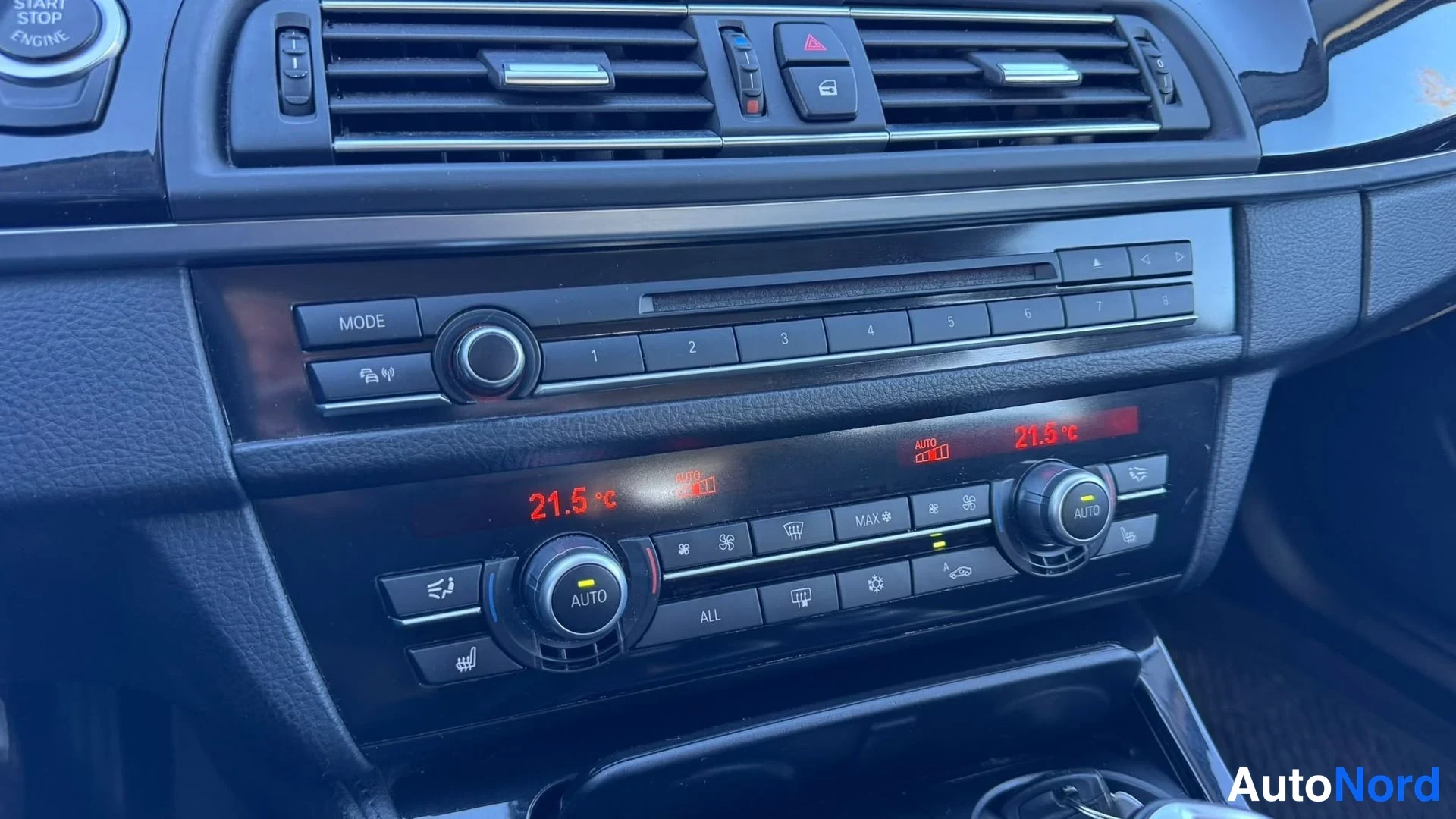 Muu: Keskikonsolin radio- ja ilmastointipaneeli: näppäimet 1–8, MODE-painike, CD-aukko sekä kaksivyöhykkeen automaattIlmastoinnin lämpötilat 21,5 °C näkyvät punaisis