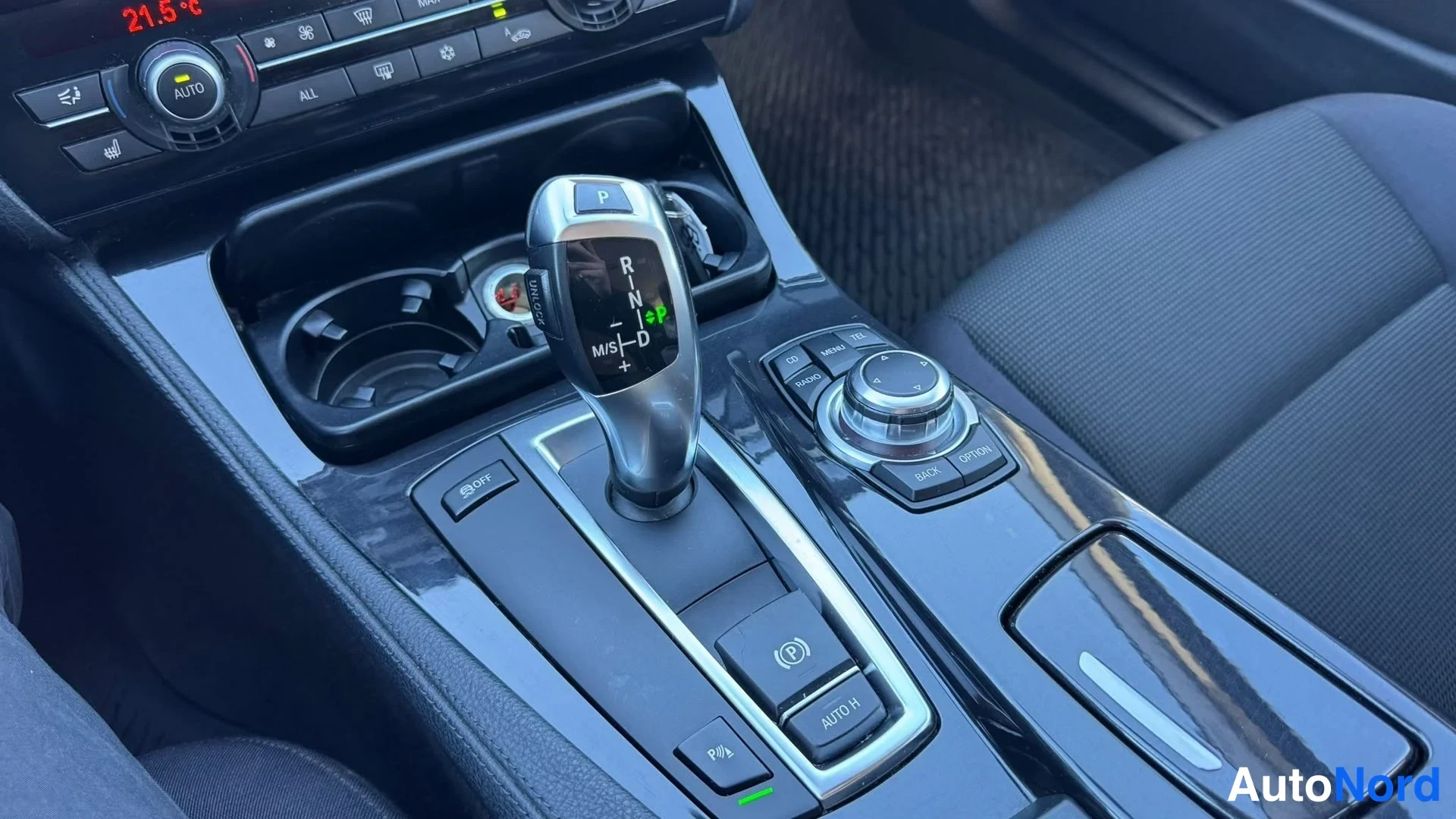 Muu: Auton keskikonsoli: automaattivaihteen valitsin (P R N D +/− M/S), iDrive-ohjainnuppi sekä electronic parking brake (P AUTO H) -kytkin.